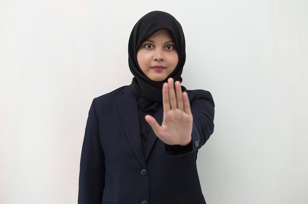 アジアのイスラム教徒のヒジャーブの女性は、手のジェスチャーを停止します