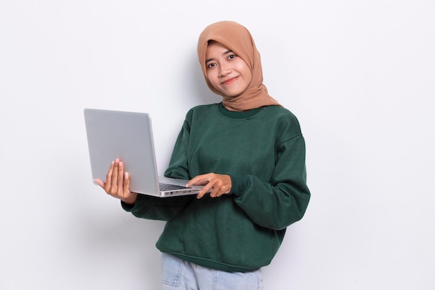 Hijab musulmano asiatico donna che utilizza il suo computer portatile isolato su sfondo bianco