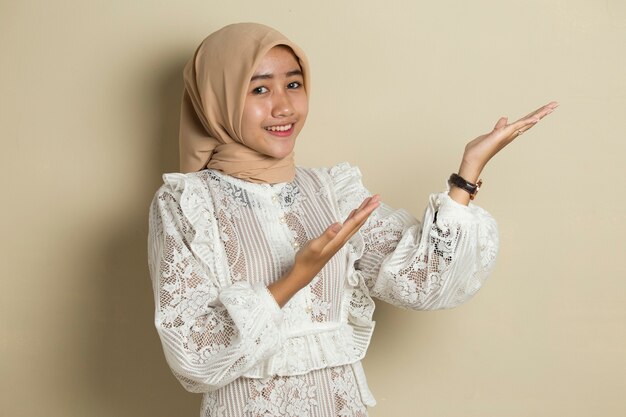 Asian muslim hijab woman with hand point on empty space