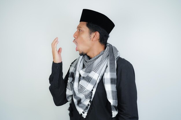 asian muslim man covering his mouth with hand or bad breath wearing Arab turban sorban on