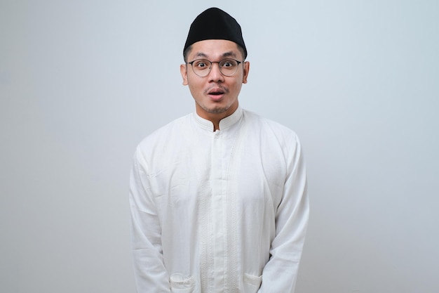 Asian muslim man shocked gesture can not believe of what he sees Worried expression against white background