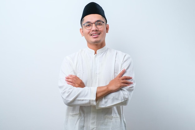 白い背景の上に腕を組んで笑っているアジアのイスラム教徒の男