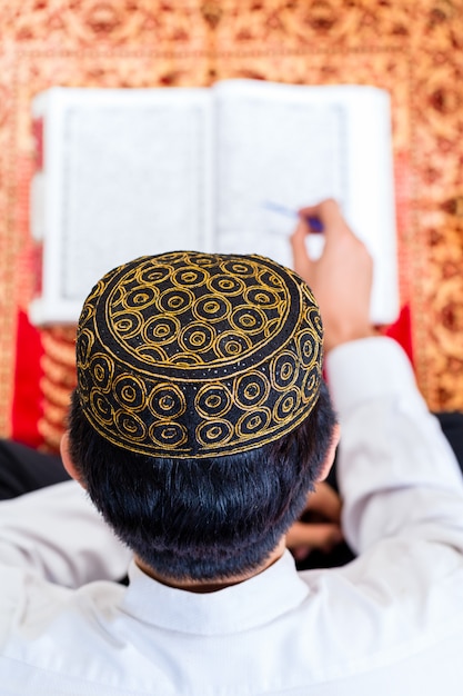 Asian Muslim man studying Koran or Quran