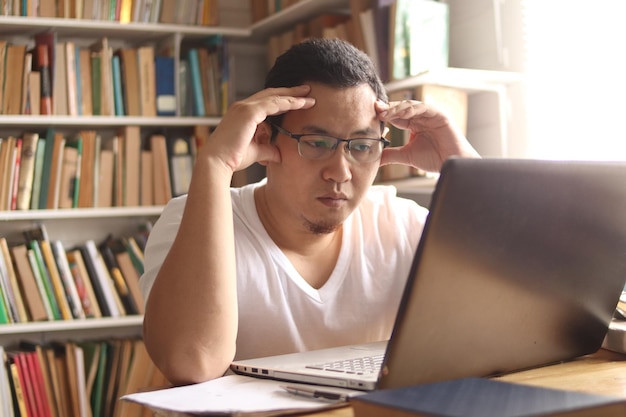 Photo asian muslim man studying in library exam preparation concept male college student