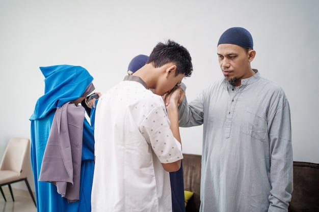 アジアのイスラム教徒の親がイドゥルフィトリイードムバラクで手を振る