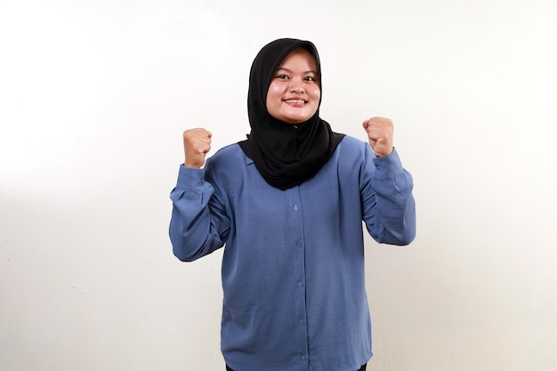 Asian muslim woman celebrating something with fist hands