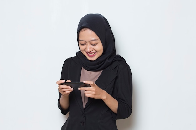 Asian muslim woman excited to play games on her smart phone