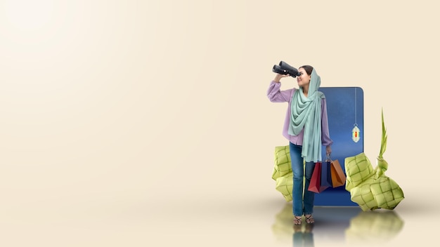 Foto donna musulmana asiatica in un velo che guarda attraverso il binocolo mentre tiene le borse della spesa