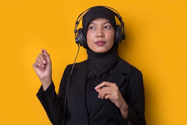 Asian Muslim woman listening to music on headphones