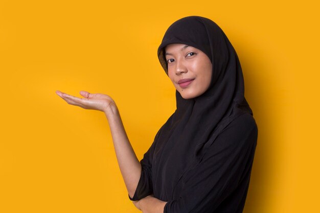 Asian muslim woman points to present an empty space