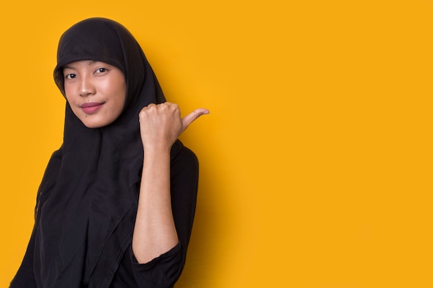 La donna musulmana asiatica indica di presentare uno spazio vuoto