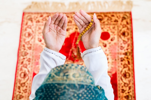 Foto donna musulmana asiatica che prega con la catena delle perle