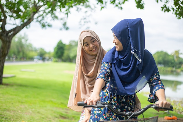 Asian muslim woman ride bicycle  in the garden