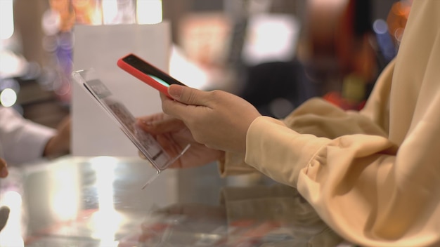 Photo asian muslim woman using contactless payment to pay for products