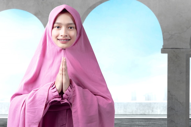 Asian Muslim woman in veil praying