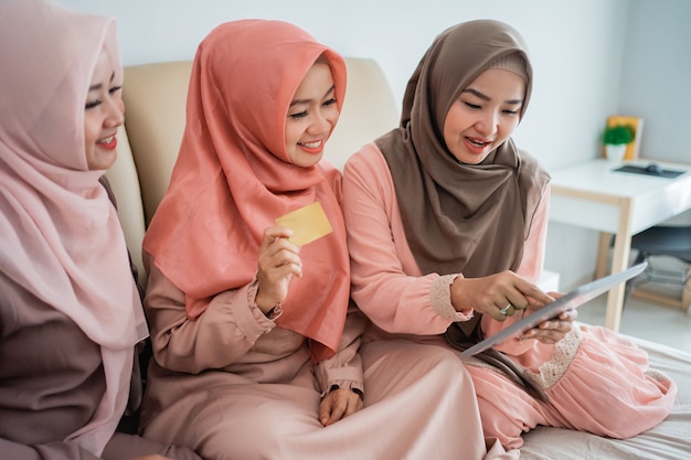 온라인 상점에서 품목을 찾기 위해 태블릿을 사용하는 아시아 이슬람 여성