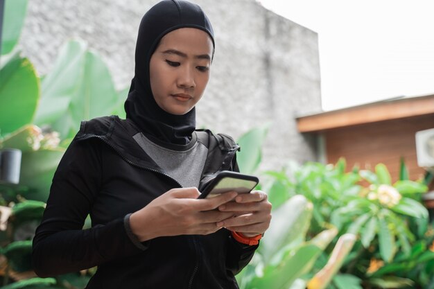 Asian muslim women wearing hijab sportswear using smartphone