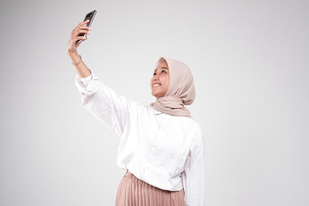 Asian muslimah take a selfie with her phone