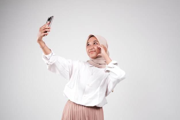 Asian muslimah take a selfie with her phone