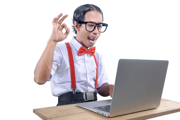 Asian nerd with an ugly face using laptop isolated over white background