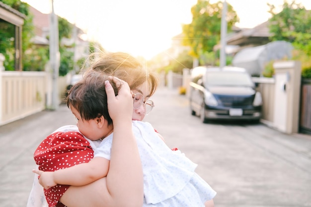 柔らかいマットレスの上で幸せな家族と一緒にいる子供たちのお母さんのかわいらしさとアジアの生まれたばかりの赤ちゃんの子供のアイコンタクト