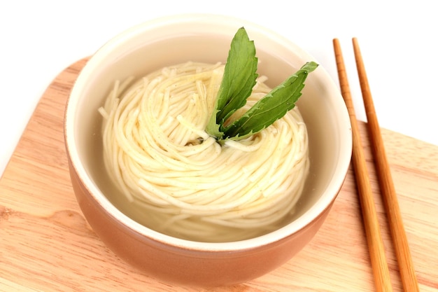 Asian noodles in bowl on wooden board closeup