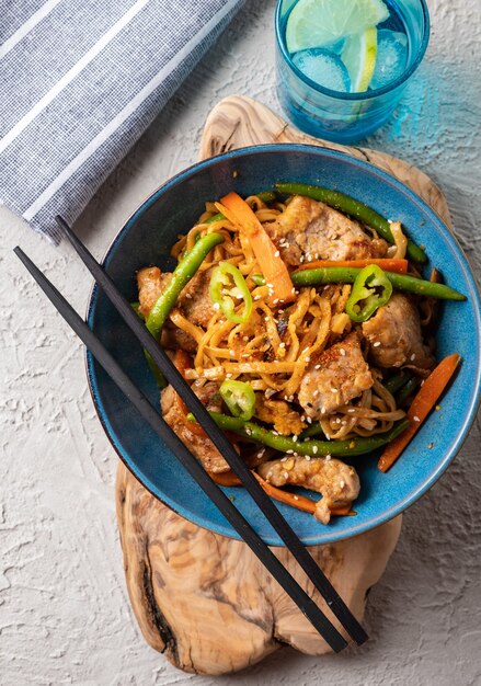 Asian noodles with pork in teriyaki sauce, with green beans, carrots and shiitake mushrooms. Top view.