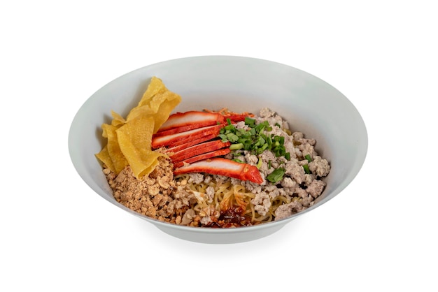 Asian noodles with pork and vegetables in bowl over white background