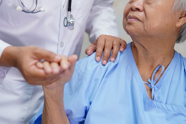 아시아 고위 여자 환자를 만지고 아시아 간호사 physiotherapist 의사