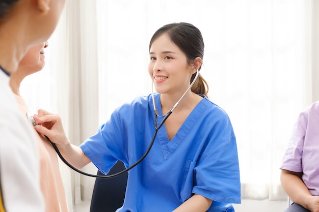 自宅で年配の女性患者の心拍数をチェックするために聴診器を使用