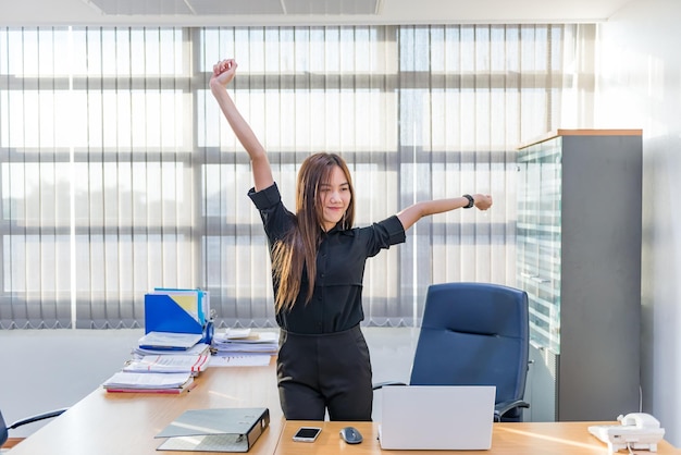 사무실 책상에서 몸을 스트레칭 하는 아시아 장교 여자