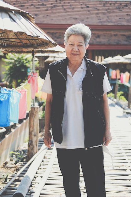 Asian old elderly female elder woman resting relaxing in garden. senior leisure lifestyle