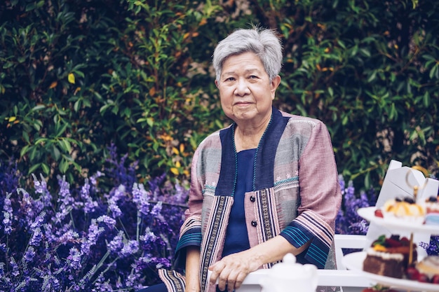 Donna anziana anziana anziana asiatica che riposa rilassante nel giardino di fiori di lavanda