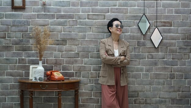 Foto vecchia donna asiatica anziana che aspetta in una stanza di casa retro vintage senza tempo