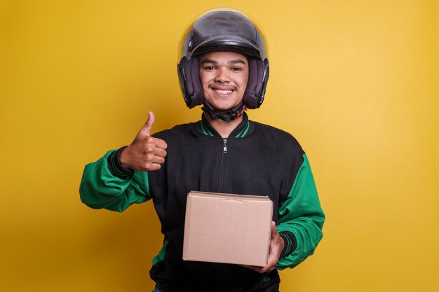 Asian online motorbike taxi driver holding to a package and giving thumbs up