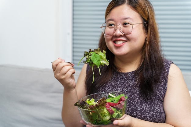 アジアの太りすぎの女性がダイエットする減量新鮮な新鮮な自家製サラダを食べる健康的な食事のコンセプト体重ダイエットのライフスタイルを持つ肥満女性