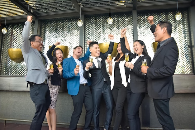 Группа азиатских людей выпивает на вечеринке, поздравляет бизнес-команду Группа друзей, наслаждающихся вечерними напитками в баре
