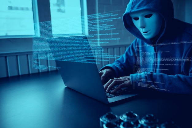 Photo asian people hacker wear a mask using a laptop cyber attack.