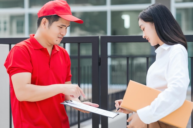 Foto le persone asiatiche hanno ricevuto una scatola di prodotti da un uomo del servizio di consegna, un moderno e-commerce, consegne a domicilio, un'esperienza di shopping conveniente, un servizio a porta a porta affidabile, catturato in un attimo.