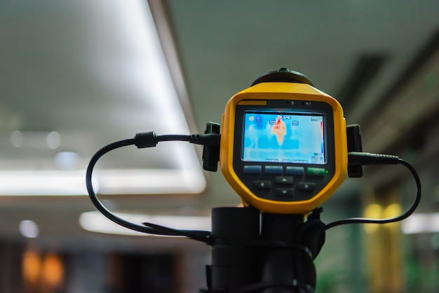 Foto persone asiatiche in attesa del controllo della temperatura corporea prima di accedere all'edificio tramite termoscansione o termocamera a infrarossi