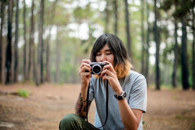 屋外の写真を撮っているアジアの写真家