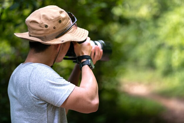 사진 아시아 사진작가는 렌즈 카메라와 자연 속에서 트레킹하는 백패커 트레일로 사진을 찍습니다.