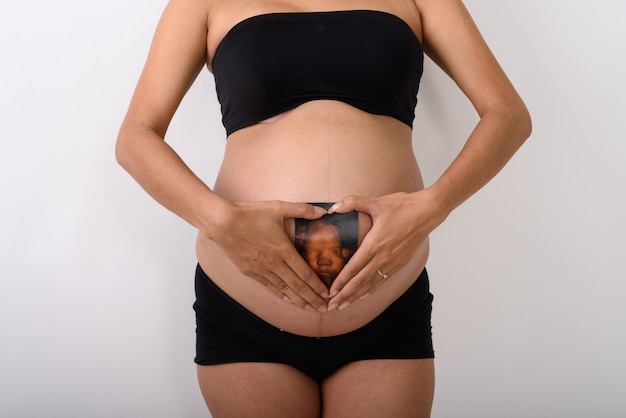 Asian pregnant woman holding sonogram of her baby