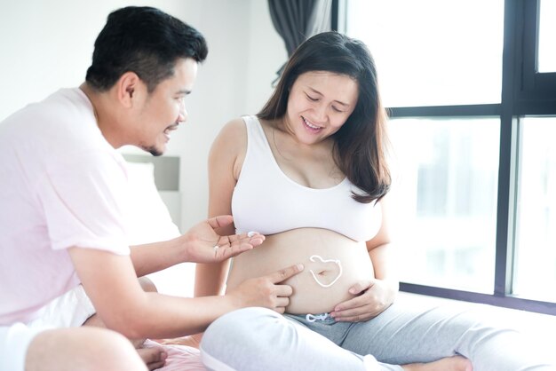 아시아 임산부입니다. 엄마와 신생아입니다. 어머니의 날과 국제 여성의 날. 집에서 남편과 함께 휴식과 레크리에이션