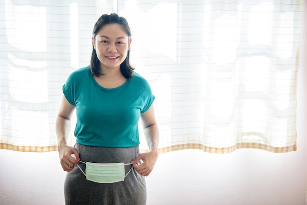 Asian pregnant woman standing and smiling