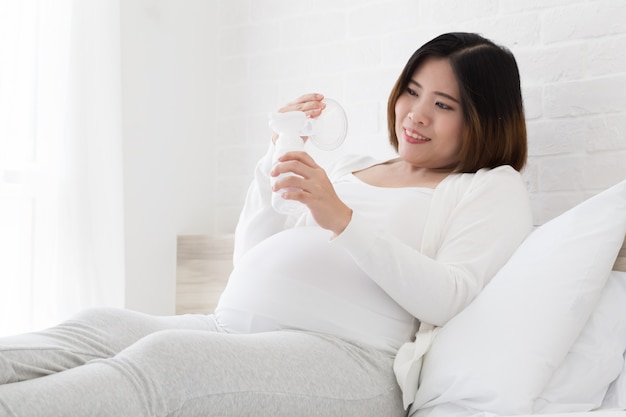 Asian pregnant women choosing a breast pump milk before give birth