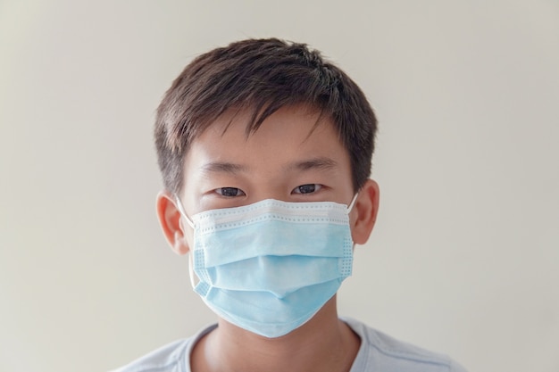 Ragazzo asiatico del preteen che indossa maschera medica, auto-quarantena, coronavirus, epidemia di epidemia di virus covid-19 pandemia