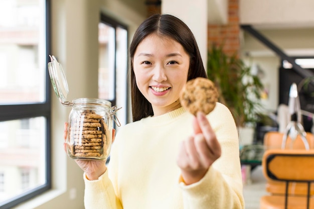 Asian pretty woman eating cookies at cool living room