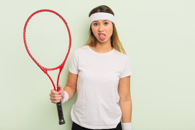 Foto bella donna asiatica che si sente disgustata e irritata e con la lingua fuori. concetto di tennis