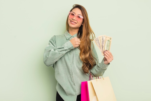 Asian pretty woman feeling happy and facing a challenge or celebrating shopping bags concept